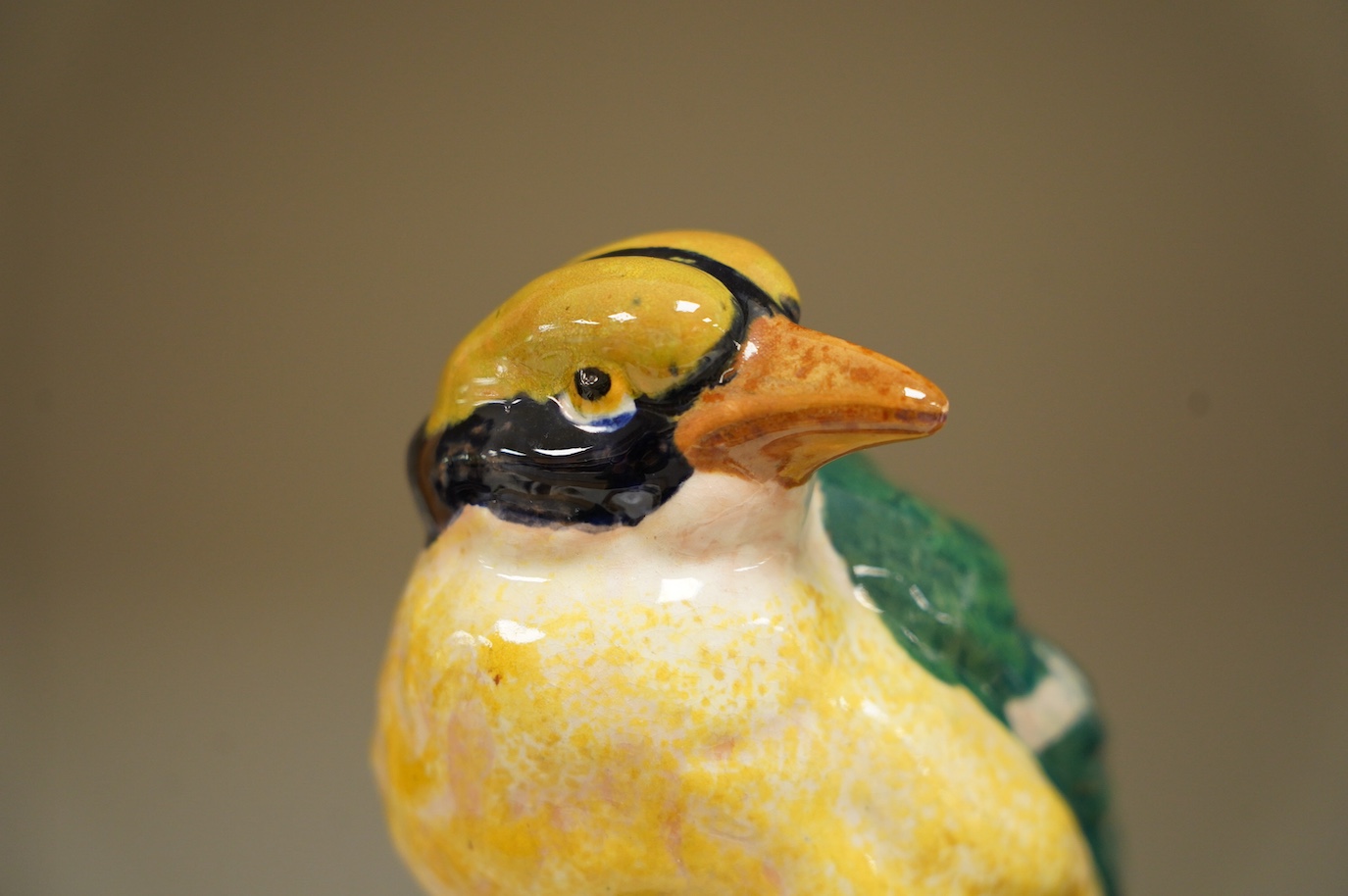 In the manner of Karlsruhe, an Austrian or Italian faience hand painted perching bird, impressed 1532 DO16 etc., 21cm high. Condition - fair to good, minor chips to base